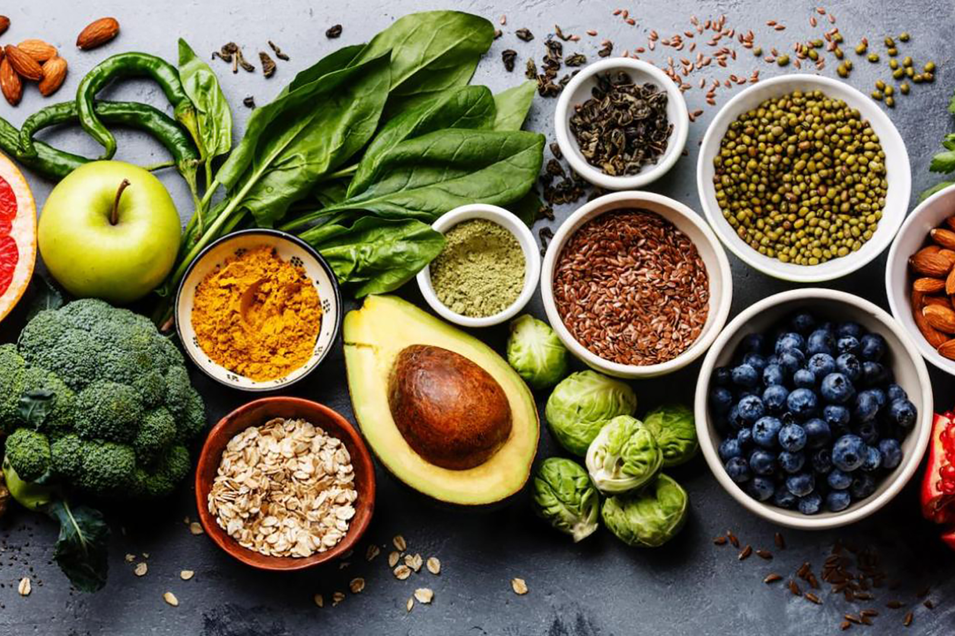 Fresh vegetables, fruits, and grains arranged on a table, symbolizing plant-based diet benefits.