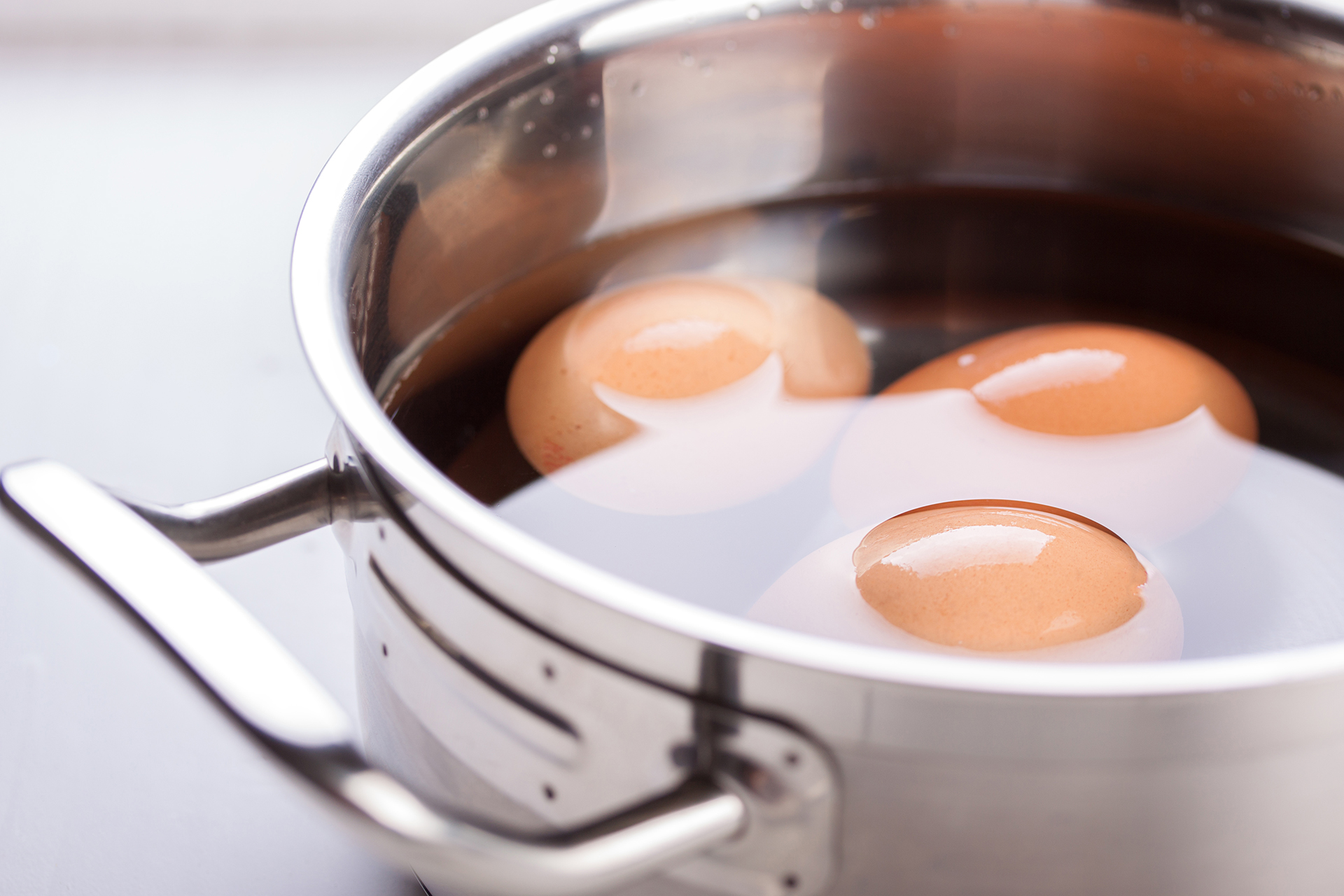 A pot of water boiling on a stove with steam rising.